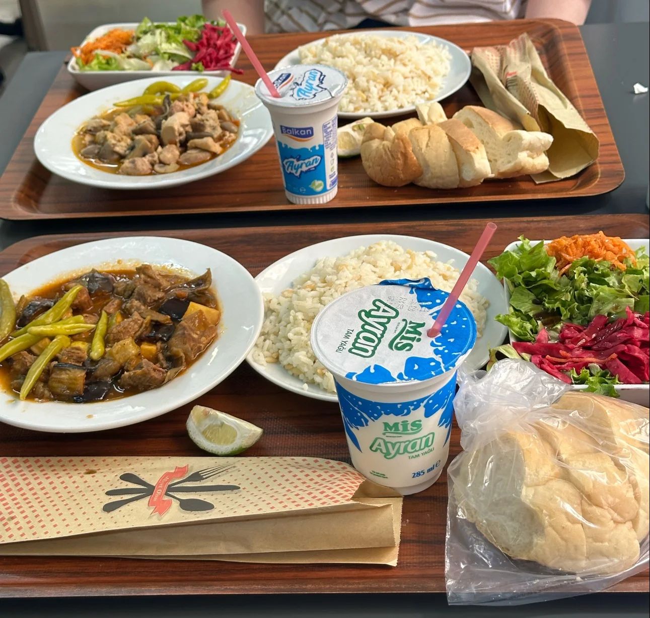 Two lunch trays with stew, rice and salad